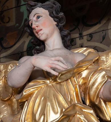 Zdjęcie nr 10: Ołtarz architektoniczny, jednoosiowy z bramkami, jednokondygnacyjny ze zwieńczeniem, na podwójnym cokole. Ołtarz murowany, licowany kamiennymi płytami, prostopadłościenny. Mensa betonowa. Antependium w formie wydłużonego, leżącego prostokąta, ujętego profilowaną ramą. Na srebrzonym polu płaskorzeźbiona, złocona dekoracja; w centrum rocaillowy kartusz ze sceną Zwiastowania Najświętszej Marii Panny, flankowany parą rocaillowych płycin, w których prawa z przedstawieniem mitry książęcej na poduszce ujętej różanymi gałązkami z gwiazdą, lewa z berłem na poduszce ujętym liliami zwieńczonej słońcem. 
Tabernaculum w formie prostopadłościennej szafki o wypukłej ścianie frontowej, z dwuskrzydłowymi drzwiczkami o kształcie zbliżonym do kwadratu, ujęte ramą; na łączeniu drzwiczek krzyż, flankowany przez odlewane kłosy zbóż i winne grono, całość na fakturowanym tle. Tabernaculum w drewnianej obudowie stanowiącej podstawę dla tronu wystawienia; cokół wyłamany, dekorowany płycinami z ornamentem roślinnym i campanullami; całość zamknięta gzymsem. Tron wystawienia w formie aediculi z obrotową niszą; ujęte parą półkolumn i parą kolumn o kapitelach kompozytowych i pseudokanelowanych trzonach dźwigających pełne belkowanie, wypukłe i wyłamane na kształt łuku odcinkowego nad niszą, wyłamane na osiach podpór. Nisza ujęta opaską dekorowaną akantem. W partii fryzu rozety i dekoracja roślinna. Całość zwieńczona postumentem  z leżącym na księdze barankiem. Tron flankują dwie figurki, adorujących aniołków, klęczących na cokole.
Nastawa ołtarzowa ujęta trzema parami pilastrów i parą skrajnych filarów o kapitelach kompozytowych i kanelowanych trzonach; oraz stojących przed nimi w dwóch strefach dwiema parami kolumn o kapitelach kompozytowych. Podpory dźwigają pełne belkowanie, wyłamane na ich osi; nad polem środkowym architraw przyjmuje kształt łuku nadwieszonego. Belkowanie oraz cokoły kolumn ustawione delikatnie pod katem względem lica retabulum. Na belkowaniu, na osi skrajnych kolumn przerwany, wolutowy przyczółek z siedzącą parą puttów. W polu środkowym  nisza w formie stojącego prostokąta zamkniętego łukiem nadwieszonym, z wklęsłymi dolnymi narożami i dolnym bokiem; ujęta profilowaną ramą; w polu płaskorzeźbiona scena z Widzeniem św. Franciszka. Zwieńczenie w formie stojącego prostokąta ujętego lizenami oraz spływami wolutowymi; zamknięte gzymsem przechodzącym w dwie zwrócone antytetycznie woluty. W polu obraz w formie stojącego owalu w profilowanej ramie z przedstawieniem św. Michała Archanioła. Retabulum ujęte bramkami z przejściami w formie stojącego prostokąta zamkniętego łukiem nadwieszonym z uskokiem, z drzwiczkami; zwieńczone podtrzymywanym przez konsolę cokołem dla figur aniołów, flankowanym spływami wolutowymi.
Cokoły dla kolumn dekorowane z trzech stron płycinami. Rama obrazu pola środkowego zdobiona na bokach rocaille z kwiatami i palmami; łuk zwieńczony rocaillowym kartuszem, flankowanym przez dwie palmy. Na gzymsie nad polem środkowym muszla. Lizeny i woluty zwieńczenia dekorowane campanullami; obraz u spodu i u góry ujęty rocaille. Na gzymsie wieńczącym dwa kwiatowe festony; na jego skraju para wazonów, całość zwieńczona stylizowanym rokokowym krzyżem.
Struktura polichromowana w kolorze kremowym, z detalami w kolorach szarym i brudnym różem; trzony kolumn marmoryzowane; ornamentyka i profile złocone.