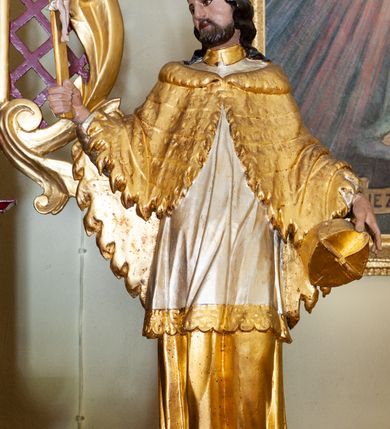 Zdjęcie nr 7: Nastawa architektoniczna, jednoosiowa, jednokondygnacyjna ze zwieńczeniem, ustawiona na cokole z wyodrębnionymi prostopadłościanami. Ołtarz drewniany, prostopadłościenny, z drewnianą mensą. Antepedium podzielone dwiema parami lizen, w centrum medalion z płyciną w formie czteroliścia, z monogramem IHS. Cokół retabulum dekorowany rozetami. Nastawa flankowana dwiema parami pilastrów i stojącą przed nimi parą kolumn o kapitelach kompozytowych, dźwigających pełne belkowanie wyłamane na ich osi, nad polem środkowym przyjmujące kształt łuku odcinkowego. Belkowanie dekorowane rozetami oraz anthemionami, nad polem środkowym małżowinowy kartusz z koroną, krzyżem i kotwicą. Na belkowaniu fragmenty przerwanego, falistego przyczółka z siedzącymi puttami. W polu środkowym nisza w formie stojącego prostokąta zamkniętego łukiem półkolistym nadwieszonym, ujęta profilowaną ramą, z figurą św. Stanisława. Nisza flankowana ornamentem małżowinowo-chrząstkowym i akantem. Kondygnacja flankowana uszami utworzonymi z akantu, karbowanej wstęgi i kratki regencyjnej. Po bokach nastawy przymocowane wsporniki z figurami św. Jana Kantego i św. Jana Nepomucena. Zwieńczenie w formie zbliżonej do prostokąta, o krawędzi kształtowanej przez woluty, dekorowanej stylizowanym ornamentem roślinnym i rokokowym. W polu prześwit w kształcie stojącego prostokąta zamkniętego łukiem półkolistym nadwieszonym, ujętym profilowaną ramą, z figurą Matki Boskiej Niepokalanie Poczętej. 
Struktura polichromowana w kolorze ciemnoczerwonym, ze złoconymi kolumnami, profilami i ornamentyką oraz srebrzonymi detalami. 

