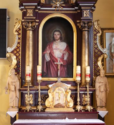 Zdjęcie nr 1: Nastawa architektoniczna, jednoosiowa, jednokondygnacyjna ze zwieńczeniem, ustawiona na cokole z wyodrębnionymi prostopadłościanami. Ołtarz drewniany, prostopadłościenny, z drewnianą mensą. Antepedium flankowane dwiema parami lizen, w centrum przedstawienie złotego krzyża na srebrzonym tle. Cokół dekorowany rozetami i akantem. Nastawa flankowana dwiema kolumnami o kapitelach kompozytowych, dźwigających pełne belkowanie wyłamane na ich osi oraz częściowo przerwane nad polem środkowym, z rozetami w partii fryzu oraz fragmenty przerwanego, wolutowego przyczółka. W polu głównym wnęka w formie stojącego prostokąta zamkniętego łukiem półkolistym, ujęta profilowaną ramą, z obrazem Najświętszego Serca Jezusa. Nad obrazem gołębica Ducha Świętego w glorii promienistej. Kondygnacja ujęta uszami utworzonymi z akantu, kratki regencyjnej i karbowanej wstęgi. Zwieńczenie w formie zbliżonej do trapezu, zamkniętego dwiema stykającymi się wolutami, ujętego spływami wolutowymi, całość obwiedziona karbowaną wstęgą. Całe pole wypełnia obraz z przedstawieniem św. Wojciecha. 
Struktura polichromowana w kolorze ciemnoczerwonym, ze złoconymi kolumnami, profilami i ornamentyką oraz srebrzonym polem zwieńczenia i detalami. 