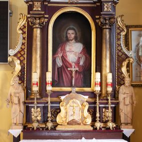 Zdjęcie nr 1: Nastawa architektoniczna, jednoosiowa, jednokondygnacyjna ze zwieńczeniem, ustawiona na cokole z wyodrębnionymi prostopadłościanami. Ołtarz drewniany, prostopadłościenny, z drewnianą mensą. Antepedium flankowane dwiema parami lizen, w centrum przedstawienie złotego krzyża na srebrzonym tle. Cokół dekorowany rozetami i akantem. Nastawa flankowana dwiema kolumnami o kapitelach kompozytowych, dźwigających pełne belkowanie wyłamane na ich osi oraz częściowo przerwane nad polem środkowym, z rozetami w partii fryzu oraz fragmenty przerwanego, wolutowego przyczółka. W polu głównym wnęka w formie stojącego prostokąta zamkniętego łukiem półkolistym, ujęta profilowaną ramą, z obrazem Najświętszego Serca Jezusa. Nad obrazem gołębica Ducha Świętego w glorii promienistej. Kondygnacja ujęta uszami utworzonymi z akantu, kratki regencyjnej i karbowanej wstęgi. Zwieńczenie w formie zbliżonej do trapezu, zamkniętego dwiema stykającymi się wolutami, ujętego spływami wolutowymi, całość obwiedziona karbowaną wstęgą. Całe pole wypełnia obraz z przedstawieniem św. Wojciecha. 
Struktura polichromowana w kolorze ciemnoczerwonym, ze złoconymi kolumnami, profilami i ornamentyką oraz srebrzonym polem zwieńczenia i detalami. 