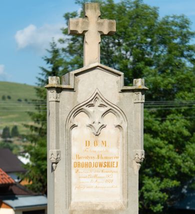 Zdjęcie nr 1: Nagrobek na dwustopniowej podstawie oraz cokole dekorowanym z przodu płyciną, na nim ustawiona stela w formie stojącego prostokąta, u dołu profilowana, zamknięta trójkątnym, nadwieszonym szczytem z krzyżem. W górnej części ujęta dwiema laskami na wspornikach, dekorowanymi maswerkiem. W polu płycina w kształcie stojącego prostokąta zamknięta łukiem w ośli grzbiet, w podłuczu dekorowana maswerkiem. Wewnątrz złocona inskrypcja: „D(EO) O(PTIMO) M(AXIMO) / Tu leżą zwłoki / ś(więtej) p(amięci) Florentyny z Fihauserów / DROHOJOWSKIEJ / Dziedziczki  dóbr Czorsztyna / urod(zonej) 27 Marca 1827 / zmar(łej) 17 Stycz(nia) 1870 / pełnej cnót chrześcijańskich.”




