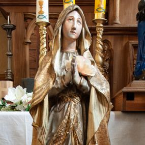 Zdjęcie nr 1: Feretron z figurą Matki Boskiej na prostopadłościennej podstawie. Maria stoi frontalnie, w lekkim kontrapoście, z prawą nogą odwiedzioną, ustawioną na kamieniu; ręce ma złożone do modlitwy. Ma delikatną, owalną twarz z wysokim czołem, długim, wąskim nosem i małymi ustami; wzrok kieruje w górę. Jest ubrana w długą, powłóczystą suknię układającą się w ostre fałdy, przepasaną szeroką szarfą z dekoracją geometryczną. Ponadto ma zarzucony okrywający głowę i ramiona płaszcz, którego spód jest prążkowany a wierzchnia strona dekorowana wicią roślinną, z bordiurą utworzoną z przeplatających się wstęg. Na nagich stopach, kamieniu i sukni aplikowane kwiaty róży. Figura ustawiona na dwudzielnej podstawie dekorowanej wicią roślinną oraz rozetami. 
Suknia Matki Boskiej jasna, szarfa oraz płaszcz pozłacane, polichromia w partiach ciała naturalistyczna; podstawa w kolorach jasnożółtym oraz brązowym. 
