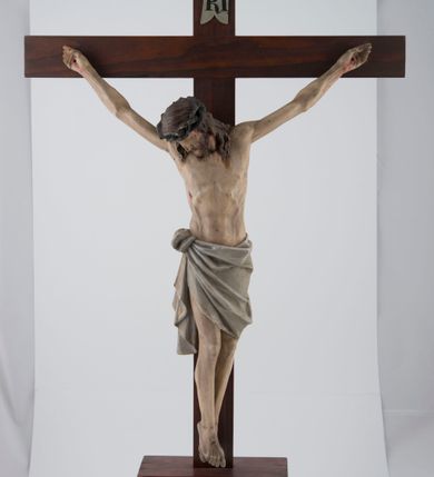 Zdjęcie nr 2: Pełnoplastyczna, polichromowana figura Chrystusa na krzyżu. Sylwetka zmarłego jest smukła, o naturalnej karnacji,  z wyraźnie zaznaczoną muskulaturą i układem kostnym. Ramiona uniesione do góry tworzą łuk, nogi są lekko skręcone w lewo. Głowa opada na prawe ramię, twarz pociągła, oczy zamknięte, nos prosty, usta zamknięte, blade. Na ramiona spływają pasma długich włosów, krótka broda dotyka torsu. Na głowie gruba, zielona korona cierniowa, biodra przewiązane białym, krótkim perizonium ze złotym paskiem przy brzegu, związanym w węzeł na prawym biodrze i opadającym pionowymi fałdami. Na ciele Chrystusa mało widoczne są ślady męki: przebity bok, dłonie oraz stopy. Nad głową titulus z napisem „IN/RI”.