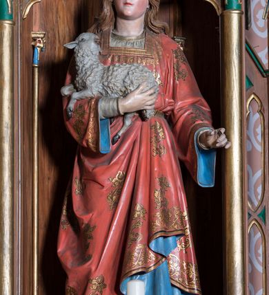 Zdjęcie nr 3: Ołtarz przyścienny, architektoniczny, trójosiowy, jednokondygnacyjny ze zwieńczeniem. Mensa skrzyniowa, prostopadłościenna. Antepedium z trzema prostokątnymi płycinami. W środkowej monogram Marii, boczne wypełnione symetrycznym ornamentem roślinnym. Predella wysoka, dekorowana fryzem arkadkowym, ostrołukowym. W pierwszej kondygnacji retabulum trzy nisze prostokątne zamknięte od góry wimpergą na tle szczytu. Środkowa nisza wyższa i szersza od bocznych, rama dekorowana wyschniętą wicią roślinną, wszystkie zdobione ażurowym ornamentem ostrołukowym i żabkami, szczyty wypełniają pola zamknięte łukiem trójlistnym, ostrym.  Boczne nisze zwieńczone ustawionymi skośnie ażurowymi kapliczkami z pinaklami, zdobionymi żabkami i kwiatonami. W środkowej niszy figura Matki Boskiej z Lourdes, w bocznych św. Kazimierza i św. Agnieszki. W zwieńczeniu ażurowa kapliczka powtarzająca kształt kapliczek wieńczących osie boczne pierwszej kondygnacji z niszą, w której figura św. Józefa z Dzieciątkiem. 
Struktura brązowa, niektóre detale malowane na zielono, ornamenty, profile i kolumny złocone. 