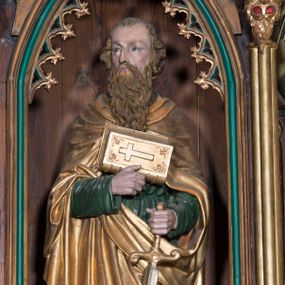 Zdjęcie nr 1: Rzeźba pełna na cokole przedstawiająca św. Pawła ukazanego w całej postaci, zwróconego nieznacznie w prawo. Święty prawą, przyciśniętą do ciała ręką podtrzymuje księgę z krzyżem na okładce, w lewej trzyma rękojeść opartego o ziemię miecza. Ma pociągłą, szczupłą twarz z okrągłymi, szeroko otwartymi oczami, prostym nosem oraz czerwonymi ustami. Okalają ją brązowe włosy, które spływając falami, zasłaniają uszy. Święty ma brodę sięgającą piersi oraz wąsy. Jest ubrany w zieloną tunikę z wąskimi rękawami, przepasaną w talii oraz płaszcz spięty na piersi. Gęsto drapowane tkaniny spływają do ziemi miękkimi fałdami. 
W partiach ciała polichromia naturalistyczna, płaszcz i atrybuty złocone i srebrzone.
