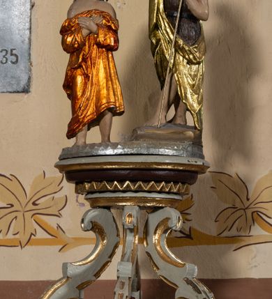 Zdjęcie nr 2: Chrzcielnica kamienna, ustawiona na dwustopniowej podstawie, na planie półkola. Stopa na planie koła, na wysokim cokole, gładka. Trzon prosty, nodus gruszkowaty, ujęty dwoma pierścieniami. Podstawa czary wklęsło-wypukła. Czara półkolista z imitacją puklowania, z wyodrębnionym brzegiem. Pokrywa drewniana, profilowana, z sześcioma kabłąkami podtrzymującymi cokół, na którym stoi grupa rzeźbiarska Chrztu Chrystusa. 


 