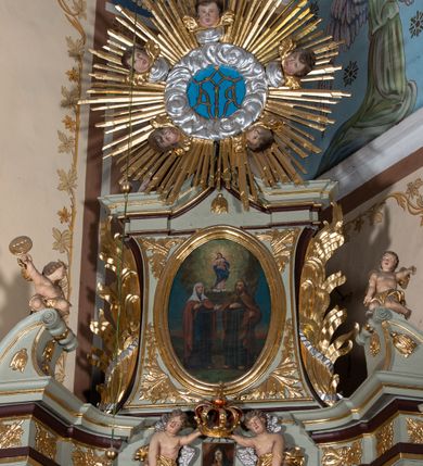 Zdjęcie nr 8: Nastawa architektoniczna, jednoosiowa, jednokondygnacyjna ze zwieńczeniem, ustawiona na cokole z wyodrębnionymi po bokach dwoma postumentami. Ołtarz prostopadłościenny z drewnianą mensą, z portatylem. Antepedium z kwiecistej tkaniny, z wyhaftowanym monogramem Marii w centrum, ujęte profilowaną ramą. Nastawa flankowana parą kolumn o skręconych trzonach i kapitelach kompozytowych stojących na tle dwóch par pilastrów o trzonach dekorowanych kampanulami. Podpory dźwigają pełne belkowanie, wyłamane na ich osi, o wklęsłym zarysie, przerwane nad polem środkowym, z fryzem dekorowanym rozetami oraz fragmenty przerwanego, falistego przyczółka ozdobionego kampanulami z parą puttów z wachlarzami. W polu nisza w formie stojącego prostokąta z obrazem Matki Boskiej Niepokalanie Poczętej w profilowanej ramie, flankowana dwiema gablotami z wotami. Nad polem środkowym dwa putta trzymające koronę zamkniętą oraz ryngraf malowany na blasze z przedstawieniem Matki Boskiej Bolesnej. Nastawa flankowana uszami utworzonymi z akantu i wstęgi regencyjnej. Zwieńczenie w formie stojącego prostokąta, o wklęsłych bokach, zamkniętego odcinkiem gzymsu wyłamanym w łuk ostry, ujęte liśćmi palmowymi z wstęgą. Całość zamknięta medalionem z monogramem Marii, w otoku z obłoków i uskrzydlonych główek anielskich, w glorii promienistej. W polu obraz przedstawiający Rodzinę Marii w formie stojącego owalu, w profilowanej ramie. Pole zwieńczenia wypełnione ornamentem roślinnym. Struktura architektoniczna polichromowana w kolorze jasnozielonym, kolumny, ornamentyka i profile złocone i srebrzone. 