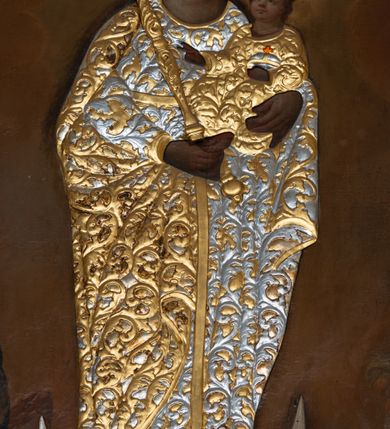 Zdjęcie nr 2: Obraz w formie stojącego prostokąta z przedstawieniem Matki Boskiej z Dzieciątkiem unoszącej się pomiędzy członkami bractwa i wiernymi. Maria ukazana jest w całej postaci, zwrócona frontalnie, z głową skierowaną w lewo, stoi na globie i na sierpie księżyca. Na lewym przedramieniu podtrzymuje Dzieciątko, w prawej dłoni trzyma berło. Maria ma pełną twarz, o okrągłych oczach i małym nosie, okoloną długimi, brązowymi włosami opadającymi wzdłuż ramion. W partii szat obraz przesłania płaskorzeźbiona sukienka, w postaci złoconej sukni o srebrzonym, akantowym wzorze oraz srebrzony płaszcz o złoconym, akantowym wzorze, narzucony na ramiona i podtrzymywany prawą ręką z przodu postaci. Maria ma na głowie płaskorzeźbioną koronę zamkniętą. Dzieciątko zwrócone jest w trzech czwartych w prawo, lewą ręką podtrzymuje jabłko królewskie, prawą błogosławi. Ma okrągłą twarz, o pełnych policzkach, okrągłych oczach skierowanych do góry, małym nosie i pełnych ustach, okoloną krótkimi, brązowymi włosami. W partii szat przesłonięte jest płaskorzeźbioną, złoconą sukienką o akantowym wzorze. Na głowie ma płaskorzeźbioną, zamkniętą koroną. Po prawej stronie Marii znajdują się dwie postacie członków bractwa w kapturach na głowach, z rękami złożonymi w geście modlitwy. Po lewej stronie Marii dwie postacie kobiece zwrócone w trzech czwartych, z rękami złożonymi w geście modlitwy. Postacie zostały ukazane na tle zachmurzonego brązowo-żółtego nieba, rozświetlonego wokół głowy Marii i Dzieciątka. W górnych narożach obraz dekorowany złoconym ornamentem rocaille'owym z kwiatami. 