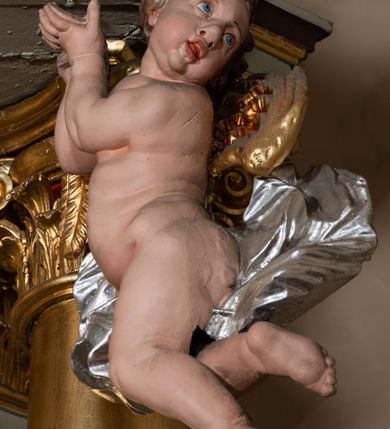 Zdjęcie nr 25: Nastawa architektoniczna, jednokondygnacyjna ze zwieńczeniem, jednoosiowa z bramkami. Ołtarz sarkofagowy z drewnianą mensą i portatylem. Na mensie znajduje się tabernakulum z tronem wystawienia. Tabernakulum w formie drewnianej skrzynki na planie wieloboku, ustawionej na cokole dekorowanym akantem, zamkniętej profilowaną listwą; ścianki dekorowane płycinami z akantem. Drzwiczki drewniane, obite blachą, w formie stojącego prostokąta, zdobione motywem krzyża, gorejącego serca, winnego grona i kłosów zboża. Tron wystawienia w formie obrotowej niszy, ujętej motywem winnego grona, flankowanej pilastrami dekorowanymi kampanulami, dźwigającymi gzyms zamykający całość, z wazonikami. Tron zwieńczony cokołem ze srebrzoną figurką leżącego baranka. 
Retabulum na dwustrefowym, uskokowym cokole ustawionym pod kątem, w górnej strefie z wyodrębnionymi po bokach postumentami i konsolami. Nastawa ujęta dwiema parami kolumn kompozytowych ustawionych na tle uskokowych, zwróconych pod kątem filarów, o trzonach dekorowanych płycinami z kampanulami. Podpory oraz dwa putta dźwigają wyłamane na ich osi, odcinkami wklęsło-wypukłe, pełne belkowanie, przerwane nad polem środkowym, z fryzem dekorowanym rozetami oraz fragmenty przerwanego, falistego przyczółka z siedzącymi na nim figurami aniołów. Na zewnętrznych krawędziach belkowania ustawione dwie figury w strojach żołnierzy. W polu środkowym nisza w formie stojącego prostokąta zamkniętego trójlistnie z uskokiem, o wklęsłych dolnych narożach, ujęta profilowaną ramą, z obrazem Trójcy Świętej i flankowana parą puttów. 
Zwieńczenie w formie stojącego prostokąta, flankowane parą zdwojonych pilastrów, zwróconych na zewnątrz, zamknięte odcinkiem gzymsu dekorowanym lambrekinem, ujęte obłokami z dwiema parami siedzących puttów. Powyżej medalion z okiem Opatrzności, ujętym obłokami i uskrzydlonymi główkami anielskimi, w glorii promienistej. W polu zwieńczenia obraz św. Jana Kantego w formie stojącego prostokąta, ujęty profilowaną ramą. 
Na wysokości cokołu nastawę flankują bramki utworzone przez postumenty przylegające do ścian prezbiterium zwieńczone fragmentami falistego przyczółka z latarniami. Cokoły przy ścianie z nastawą łączą listwy, tworząc przejścia, nad którymi stoją figury św. Piotra i św. Pawła. 
Struktura polichromowana w kolorze jasnozielonym, z brązowymi detalami, czerwonymi kapitelami; kolumny, ornamentyka i profile złocone, gloria i obłoki srebrzone. 

