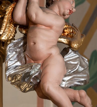 Zdjęcie nr 29: Nastawa architektoniczna, jednokondygnacyjna ze zwieńczeniem, jednoosiowa z bramkami. Ołtarz sarkofagowy z drewnianą mensą i portatylem. Na mensie znajduje się tabernakulum z tronem wystawienia. Tabernakulum w formie drewnianej skrzynki na planie wieloboku, ustawionej na cokole dekorowanym akantem, zamkniętej profilowaną listwą; ścianki dekorowane płycinami z akantem. Drzwiczki drewniane, obite blachą, w formie stojącego prostokąta, zdobione motywem krzyża, gorejącego serca, winnego grona i kłosów zboża. Tron wystawienia w formie obrotowej niszy, ujętej motywem winnego grona, flankowanej pilastrami dekorowanymi kampanulami, dźwigającymi gzyms zamykający całość, z wazonikami. Tron zwieńczony cokołem ze srebrzoną figurką leżącego baranka. 
Retabulum na dwustrefowym, uskokowym cokole ustawionym pod kątem, w górnej strefie z wyodrębnionymi po bokach postumentami i konsolami. Nastawa ujęta dwiema parami kolumn kompozytowych ustawionych na tle uskokowych, zwróconych pod kątem filarów, o trzonach dekorowanych płycinami z kampanulami. Podpory oraz dwa putta dźwigają wyłamane na ich osi, odcinkami wklęsło-wypukłe, pełne belkowanie, przerwane nad polem środkowym, z fryzem dekorowanym rozetami oraz fragmenty przerwanego, falistego przyczółka z siedzącymi na nim figurami aniołów. Na zewnętrznych krawędziach belkowania ustawione dwie figury w strojach żołnierzy. W polu środkowym nisza w formie stojącego prostokąta zamkniętego trójlistnie z uskokiem, o wklęsłych dolnych narożach, ujęta profilowaną ramą, z obrazem Trójcy Świętej i flankowana parą puttów. 
Zwieńczenie w formie stojącego prostokąta, flankowane parą zdwojonych pilastrów, zwróconych na zewnątrz, zamknięte odcinkiem gzymsu dekorowanym lambrekinem, ujęte obłokami z dwiema parami siedzących puttów. Powyżej medalion z okiem Opatrzności, ujętym obłokami i uskrzydlonymi główkami anielskimi, w glorii promienistej. W polu zwieńczenia obraz św. Jana Kantego w formie stojącego prostokąta, ujęty profilowaną ramą. 
Na wysokości cokołu nastawę flankują bramki utworzone przez postumenty przylegające do ścian prezbiterium zwieńczone fragmentami falistego przyczółka z latarniami. Cokoły przy ścianie z nastawą łączą listwy, tworząc przejścia, nad którymi stoją figury św. Piotra i św. Pawła. 
Struktura polichromowana w kolorze jasnozielonym, z brązowymi detalami, czerwonymi kapitelami; kolumny, ornamentyka i profile złocone, gloria i obłoki srebrzone. 

