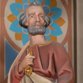 Zdjęcie nr 1: Rzeźba drążona z tyłu, ustawiona na podstawie na planie kwadratu o ściętych narożach. Święty ukazany jest w całej postaci, zwrócony frontalnie, z głową skierowaną w lewo, w kontrapoście. Lewą ręką trzyma przy boku księgę, prawą z kluczami w dłoni kładzie na piersi. Twarz ma pociągłą, o głęboko osadzonych oczach, uniesionych brwiach, dużym nosie i pełnych ustach, okoloną krótką, gęstą brodą oraz siwymi, krótkimi włosami z kosmykiem nad czołem. Ubrany jest w długą, czerwoną tunikę ze złoconą lamówką oraz osłaniający prawe ramię i zawinięty wokół postaci szary płaszcz ze złotą lamówką. Polichromia naturalistyczna w partiach ciała. 