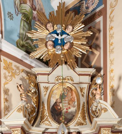 Zdjęcie nr 5: Nastawa architektoniczna, jednoosiowa, jednokondygnacyjna ze zwieńczeniem, ustawiona na cokole z wyodrębnionymi po bokach dwoma postumentami. Ołtarz prostopadłościenny z drewnianą mensą, z portatylem. Antepedium z kwiecistej tkaniny, z wyhaftowanym monogramem IHS w centrum, ujęte profilowaną ramą. Nastawa flankowana parą kolumn o skręconych trzonach i kapitelach kompozytowych stojących na tle dwóch par pilastrów o trzonach dekorowanych kampanulami. Podpory dźwigają pełne belkowanie, wyłamane na ich osi, przerwane nad polem środkowym, z fryzem dekorowanym rozetami oraz fragmenty przerwanego, falistego przyczółka ozdobionego kampanulami z parą puttów. Po zewnętrznej stronie kolumn, na wspornikach stoją figury św. Augustyna i św. Jana Kantego. W polu środkowym nisza w formie stojącego prostokąta z obrazem św. Mikołaja w profilowanej ramie. Nad polem środkowym dwa putta trzymające kwiaty, pomiędzy nimi infuła. Nastawa flankowana uszami utworzonymi z akantu przeplatanego wstęgą regencyjną. Zwieńczenie w formie pionowego prostokąta, o wklęsłych bokach, zamkniętego odcinkiem gzymsu wyłamanym w łuk ostry, ujęte liśćmi palmowymi z wstęgą. Całość zamknięta medalionem z gołębicą Ducha Świętego wśród obłoków i uskrzydlonych główek anielskich, w glorii promienistej. W polu obraz przedstawiający św. Franciszka przed Jezusem i Marią w formie stojącego owalu, w profilowanej ramie. Pole zwieńczenia wypełnione ornamentem roślinnym. Struktura architektoniczna polichromowana w kolorze jasnozielonym, kolumny, ornamentyka i profile złocone i srebrzone. 
