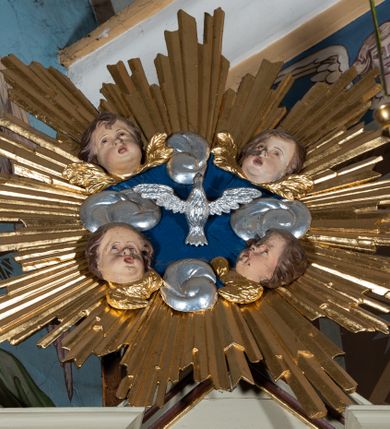 Zdjęcie nr 3: Obraz w formie stojącego owalu z przedstawieniem św. Franciszka stojącego przed Chrystusem i Marią. W dolnej części obrazu święty ukazany jest w półpostaci, zwrócony profilem w lewo, z uniesioną głową. Lewą rękę kładzie na piersi, prawą trzyma srebrzoną kartę ze złoconym napisem „NA WIEKI / NA WIEKI / NA WIEKI”, którą przekazuje mu Chrystus. Franciszek ma szczupłą twarz, okoloną krótką brodą, z tonsurą na głowie. Ubrany jest w brązowy habit franciszkański przewiązany sznurem. Przed nim w górnej części obrazu przedstawieni są pośród obłoków Maria i Chrystus. Oboje ukazani są w półpostaci, zwróceni w trzech czwartych w prawo, z pochylonymi głowami. Po prawej przedstawiona jest Maria, lewą rękę kładzie na piersi, prawą unosi w geście błogosławieństwa. Ma twarz o młodzieńczych rysach, okoloną długimi brązowymi włosami. Ubrana jest w różową suknię, zakrytą jasnoniebieskim płaszczem, na głowie ma półprzeźroczysty, biały welon. Po lewej stronie ukazany Chrystus, który prawą ręką podaje kartę Franciszkowi. Ma twarz o wyraźnych rysach, okoloną krótką brodą oraz jasnobrązowymi włosami sięgającymi ramion. Ubrany jest w jasnoróżową tunikę i płaszcz. Obok Chrystusa ukazane jest putto obsypujące Franciszka różami. Postacie Marii i Chrystusa ukazane są na tle glorii, ujęte po prawej uskrzydlonymi główkami anielskimi na tle obłoków.