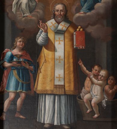 Zdjęcie nr 1: Obraz w formie stojącego prostokąta. W centrum przedstawienie św. Mikołaja z Jezusem i Marią unoszących się na obłokach w górnej części dzieła. Święty ukazany w całej postaci, frontalnie, lewą ręką podtrzymuje księgę z trzema kulami, prawą unosi z dłonią w geście błogosławieństwa. Twarz ma kwadratową z wysokim czołem, o starczych rysach, dużych oczach, prostym nosie i pełnych, rozchylonych ustach, okoloną siwą, kręcona brodą oraz siwymi, kręconymi włosami, sięgającymi ramion. Święty ubrany jest w strój biskupa wschodniego: biały sticharion, żółty sakkos z palicą przy boku oraz omoforion, na stopach ma buty. Po lewej stronie świętego znajduje się szaflik z trójką dzieci. Po jego prawej stronie postać młodzieńca, o pełnej, rumianej twarzy, okolonej jasnymi, kręconymi włosami, ubranego w niebieską tunikę sięgającą kolan oraz jasnoczerwony płaszcz zapięty na prawym ramieniu. Chłopiec trzyma tacę z karafką i dwoma kubkami. Postacie ukazane we wnętrzu. W górnej części obrazu centrycznie rozchodzące się, rozświetlone obłoki. W prawym górnym rogu siedząca na obłoku postać Chrystusa, skierowanego w trzech czwartych w lewo, który w lewej ręce trzyma księgę, a w prawej, opartej na globie, berło. Ubrany jest w czerwoną tunikę i biały płaszcz. Księgę podaje mu putto. W lewym górnym rogu siedząca na obłoku postać Marii, zwróconej w trzech czwartych w prawo, w obu wyciągniętych w przód dłoniach trzyma omoforion. Ubrana jest w jasnoróżową tunikę, przepasaną w talii, niebieski płaszcz i zielony welon. 
