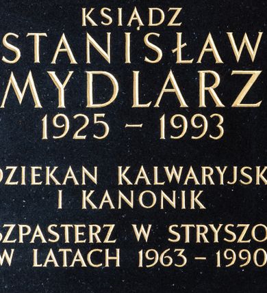 Zdjęcie nr 1: Epitafium granitowe w formie kwadratu, w narożach cztery metalowe śruby. W polu inskrypcja „D(EO) O(PTIMO) M(AXIMO) / KSIĄDZ / STANISŁAW / MYDLARZ / 1925 - 1993 / DZIEKAN KALWARYJSKI / I KANONIK / DUSZPASTERZ W STRYSZOWIE / W LATACH 1963 - 1990”.
