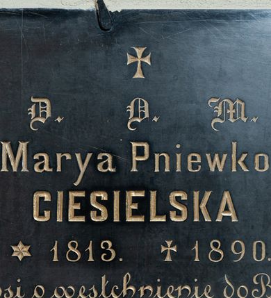Zdjęcie nr 1: Tablica w kształcie leżącego prostokąta z wyrytym poniżej niewielkiego krzyża łacińskiego złoconym napisem „D(EO) O(PTIMO) M(AXIMO) / Marya Pniewko / CIESIELSKA / *1813. +1890. / prosi o westchnienie do Boga”. 