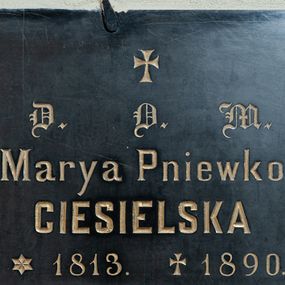 Zdjęcie nr 1: Tablica w kształcie leżącego prostokąta z wyrytym poniżej niewielkiego krzyża łacińskiego złoconym napisem „D(EO) O(PTIMO) M(AXIMO) / Marya Pniewko / CIESIELSKA / *1813. +1890. / prosi o westchnienie do Boga”. 