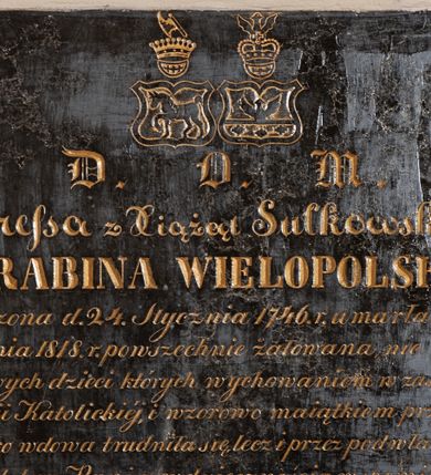 Zdjęcie nr 1: Tablica epitafijna w kształcie zbliżonym do kwadratu ze skomponowaną z różnej wielkości i typów  pisma inskrypcją poniżej herbów Starykoń i Sulima. Upamiętniający zmarłą napis został pozłocony. „D(EO) O(PTIMO) M(AXIMO) / Teresa z Xiążąt Sułkowskich / HRABINA WIELOPOLSKA / urodzona d(nia) 24. Stycznia 1746. r(oku) umarła d(nia) 18. / Grudnia 1818 r(oku) powszechnie żałowana nie tylko / od swych dzieci których wychowaniem w zasadach / Religii Katolickiej, i wzorowo maiątkiem przez lat / 45. iako wdowa trudniła się, lecz i przez podwładnych / iako dobra Pani z wdzięcznością wspominana / poleca się modliwtom ze Jey duszę”. 