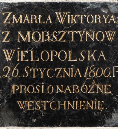 Zdjęcie nr 1: Epitafium z czarnego marmuru w formie zbliżonej do kwadratu ze złoconą inskrypcją „ZMARŁA WIKTORYA / Z MORSZTYNOW / WIELOPOLSKA / D(NIA) 26. STYCZNIA 1800 R(OK)U / PROSI O NABOŻNE / WESTCHNIENIE”. 