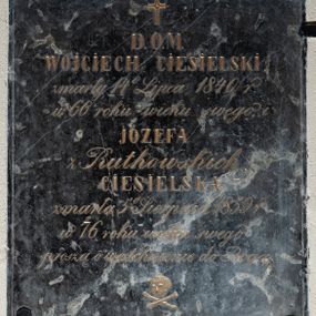 Zdjęcie nr 1: Tablica w kształcie stojącego prostokąta z wyrytym między niewielkim krzyżem łacińskim a czaszką powyżej skrzyżowanych piszczeli złoconym napisem „D(EO) O(PTIMO) M(AXIMO) / WOJCIECH CIESIELSKI / zmarły 14 Lipca 1840 r(oku) / w 66 roku wieku swego i / JÓZEFA / z Rutkowskich / CIESIELSKA / zmarła 5 Sierpnia 1859 r(oku) / w 76 roku wieku swego / proszą o westchnienie do Boga”. Pole napisu obwiedziono cienką, rytą ramką. 