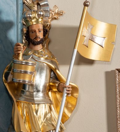 Zdjęcie nr 1: Rzeźba drążona, ustawiona na cokole. Postać przedstawiona frontalnie, w kontrapoście. W prawej, uniesionej w górę ręce trzyma cebrzyk na wodę, w lewej chorągiew z krzyżem łacińskim. Twarz ma pociągłą, okoloną krótką brodą, o szeroko otwartych oczach i wysokim czole. Włosy ma kręcone, zaczesane do tyłu, na głowie mitrę książęcą. Święty ubrany jest w tunikę sięgającą kolan, puklerz, nagolenniki oraz spięty pod szyją płaszcz z gronostajem. Polichromia naturalistyczna w odsłoniętych partiach ciała, elementy zbroi srebrzone, tkanina i atrybuty złocone i srebrzone. 