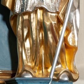 Zdjęcie nr 1: Rzeźba drążona, na cokole. Święty zwrócony frontalnie, w kontrapoście, o esowato wygiętej sylwetce, z głową przechyloną na prawe ramię. Prawą rękę unosi w geście błogosławieństwa, w lewej trzyma pastorał. Twarz ma pociągłą, oczy niewielkie, wydatny nos. Włosy długie, kręcone, opadające na ramiona. Jest ubrany w złoconą albę, srebrzoną komżę z koronką przy brzegu, złocony mucet z guzikami oraz srebrzony płaszcz zapięty na piersi, ze złoconą lamówką i podbiciem; na głowie ma złoconą infułę, na dłoniach rękawiczki. Polichromia naturalistyczna w odsłoniętych partiach ciała, strój i atrybuty złocone i srebrzone.