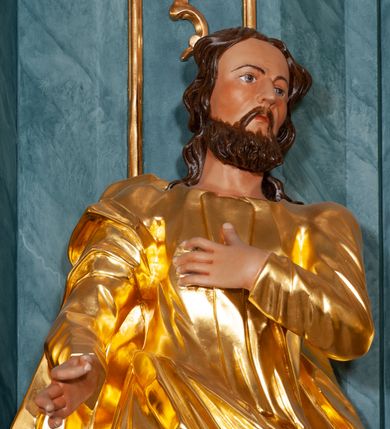Zdjęcie nr 3: Rzeźba ścięta z tyłu, drążona. Figura ustawiona na rzeźbionym cokole, ustawiona frontalnie, w kontrapoście, z głową skierowaną w lewo. Lewa ręka świętego spoczywa na piersi, prawa jest wyciągnięta w przód.Twarz pociągła, okolona krótką, kręconą brodą. Włosy półdługie, kręcone, opadają na tył głowy. Święty jest ubrany w tunikę przepasaną w talii, ściśle przylegającą w partii torsu oraz obficie drapowany płaszcz przewieszony przez prawe ramię, otaczający postać i podwieszony na prawym boku.
Polichromia naturalistyczna w odsłoniętych partiach ciała, szaty złocone.