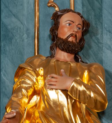 Zdjęcie nr 2: Rzeźba ścięta z tyłu, drążona. Figura ustawiona na rzeźbionym cokole, ustawiona frontalnie, w kontrapoście, z głową skierowaną w lewo. Lewa ręka świętego spoczywa na piersi, prawa jest wyciągnięta w przód.Twarz pociągła, okolona krótką, kręconą brodą. Włosy półdługie, kręcone, opadają na tył głowy. Święty jest ubrany w tunikę przepasaną w talii, ściśle przylegającą w partii torsu oraz obficie drapowany płaszcz przewieszony przez prawe ramię, otaczający postać i podwieszony na prawym boku.
Polichromia naturalistyczna w odsłoniętych partiach ciała, szaty złocone.