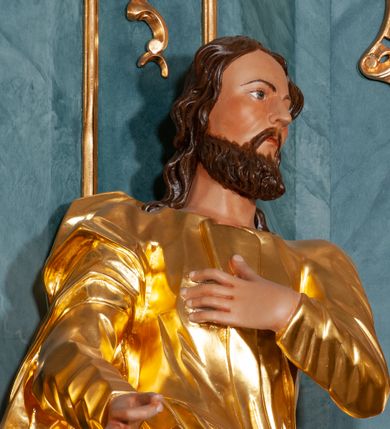 Zdjęcie nr 6: Rzeźba ścięta z tyłu, drążona. Figura ustawiona na rzeźbionym cokole, ustawiona frontalnie, w kontrapoście, z głową skierowaną w lewo. Lewa ręka świętego spoczywa na piersi, prawa jest wyciągnięta w przód.Twarz pociągła, okolona krótką, kręconą brodą. Włosy półdługie, kręcone, opadają na tył głowy. Święty jest ubrany w tunikę przepasaną w talii, ściśle przylegającą w partii torsu oraz obficie drapowany płaszcz przewieszony przez prawe ramię, otaczający postać i podwieszony na prawym boku.
Polichromia naturalistyczna w odsłoniętych partiach ciała, szaty złocone.