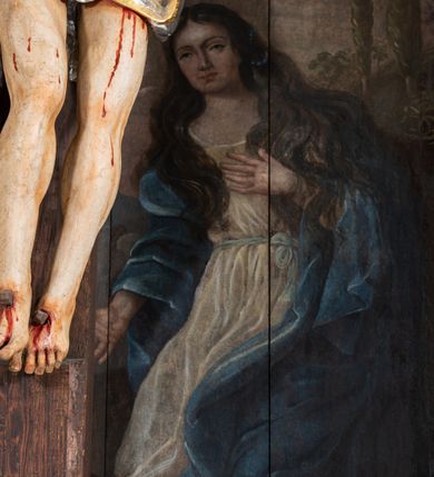 Zdjęcie nr 15: Pole główne ołtarza wypełnia figura Chrystusa Ukrzyżowanego na tle obrazu. Rzeźba pełna przedstawia żywego jeszcze Zbawiciela. Ciało oddano w dużym zwisie, o układzie ramion zbliżonym do litery „V” i esowato wygiętej sylwetce. Jezus ma nogi ugięte w kolanach, stopy przybite dwoma gwoździami, prawą nad lewą. Ciało szczupłe o wyraźnie podkreślonej muskulaturze i pracy mięśni, z zaznaczonymi śladami męki na lewym boku i w miejscach przebicia gwoździami. Głowa w grubej koronie cierniowej, przechylona na lewe ramię, uniesiona, ze wzrokiem skierowanym do góry. Twarz szczupła, okolona krótką brodą, nos długi, wąski, usta rozchylone. Włosy kręcone w pukle opadają na lewe ramię i plecy. Perizonium krótkie, utworzone ze skręconej, drapowanej i skrzyżowanej tkaniny, ze złoconą lamówką; przewiązane na prawym boku sznurem z chwostami, z obfitym, gęsto drapowanym zwisem sięgającym kolan. Polichromia naturalistyczna w partiach ciała; perizonium srebrzone i złocone, korona cierniowa i sznur złocone. W górnej części pionowej belki krzyża titulus w formie zwoju z napisem „IN/RI”. W tle, po prawej stronie krzyża postać klęczącej Marii Magdaleny, zwróconej w trzech czwartych w stronę Chrytsusa. Jej lewa ręka spoczywa na piersi, prawa ujmuje belkę krzyża. Ma pełną, młodzieńczą twarz, włosy długie, opadające na ramiona i plecy z wplecionymi sznurami pereł. Ubrana jest w białą suknię przewiązaną w talii oraz niebieski płaszcz połamany w grube fałdy na rękawach. U jej nóg puszka na wonności. W lewej dolnej części obrazu przedstawienie Jerozolimy wśród gór. Obraz w połowie przecina jaśniejsza linia horyzontu, powyżej widoczne ciemne niebo z kłębiastymi chmurami. Kolorystyka obrazu ciemna, kontrastująca z figurą Ukrzyżowanego. 