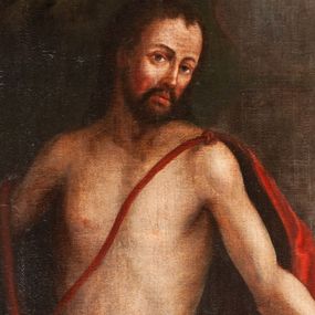 Zdjęcie nr 1: Obraz w kształcie stojącego prostokąta w profilowanej, złoconej i srebrzonej ramie z przedstawieniem św. Jana Chrzciciela. Święty stoi w centrum kompozycji w lekkim kontrapoście, skręcony delikatnie w prawo, z głową obróconą na lewe ramię. Prawą rękę unosi do boku, w lewej trzyma długie drzewce zakończone krzyżem z przewiązaną banderolą z napisem „ECCE AGNUS DEI”. Ma szczupłą, owalną twarz z wysokim czołem, wąskim nosem i dużymi, ciemnymi oczami. Nosi wąsy i krótką brodę, a długie włosy spływają mu na plecy. Święty ma narzucony czerwony, podbity brązem płaszcz przewiązany na lewym ramieniu szarfą, przerzucony przez prawe przedramię i otaczający biodra. U jego stóp, po lewej stronie kompozycji, na księdze w czerwonej oprawie leży niewielki baranek. Z prawej strony u dołu widać wznoszącą wzrok na świętego rodzinę złożoną ze starszego mężczyzny w niebieskiej sukni i żółtym płaszczu, kobiety w jasnych szatach i dziecka. Święty Jan został ukazany na tle ciemnego lasu lub bloku skalnego i skłębionego, szarego obłoku, ponad którym unosi się główka anielska. Przy prawej krawędzi widoczny fragment szerokiego krajobrazu stanowiącego brzeg rzeki lub morza. 