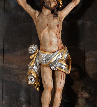 Zdjęcie nr 19: Nastawa ołtarzowa jednoosiowa, jednokondygnacyjna ze zwieńczeniem, na podwójnym cokole. Mensa ołtarzowa drewniana, prostopadłościenna. Antepedium w formie leżącego prostokąta w profilowanej ramie. Pole dekorowane rzeźbionym akantem o układzie symetrycznym względem osi środkowej, z elementami muszli oraz parą puttów po dwóch stronach centralnie ustawionej łodygi z kwiatem. Tabernakulum w formie prostopadłościanu zamkniętego gzymsem. Drzwiczki w kształcie stojącego prostokąta zamkniętego łukiem nadwieszonym w profilowanej ramie z płaskorzeźbionym przedstawieniem zmartwychwstałego Chrystusa; ujęte płyciną, dekorowaną w przyłuczach polami z akantem. Chrystus został ukazany w całej postaci, lewą ręka przytrzymując krzyż, prawą wskazuje ranę w boku. Przy jego prawej nodze stoi kielich. Pierwsza kondygnacja nastawy ujęta dwiema parami kolumn o kapitelach kompozytowych i kanelowanych trzonach o kwadratowym przekroju, ustawionych przed pilastrami; wewnętrzna para ustawiona skośnie względem lica ołtarza. Podpory dźwigają pełne belkowanie wyłamane na ich osi, przerwane nad polem środkowym; wewnętrzna para podtrzymuje imposty oraz przerwany, esowaty przyczółek z siedzącymi przed nim, na gzymsie, figurami aniołów w długich sukniach. Pole środkowe kondygnacji w formie stojącego prostokąta zamkniętego łukiem półkolistym nadwieszonym z wnęką z figurą Chrystusa Ukrzyżowanego na malowanym tle z Jerozolimą i postacią św. Marii Magdaleny. Zwieńczenie w formie bardzo rozbudowanej glorii promienistej, o naprzemiennie długich i krótkich wiązkach promieni; z płaskorzeźbionym mandylionem podtrzymywanym u spodu i po bokach przez trzy putta. Chustę św. Weroniki od góry i od dołu ujmują skłębione obłoki, między którymi widoczne główki anielskie. 
Oba cokoły dekorowane płycinami: w partii dolnego cokołu wypełnionymi ciemnoróżową marmoryzacją, w partii górnego ornamentem akantowym, mniejsze płyciny w partii fryzu. Struktura polichromowana na kolor jasnoszary, pola płycin i profilowania czerwone; kolumny, gloria, ornamentyka i profilowania złocone; chusta i obłoki srebrzone.
