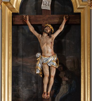 Zdjęcie nr 21: Nastawa ołtarzowa jednoosiowa, jednokondygnacyjna ze zwieńczeniem, na podwójnym cokole. Mensa ołtarzowa drewniana, prostopadłościenna. Antepedium w formie leżącego prostokąta w profilowanej ramie. Pole dekorowane rzeźbionym akantem o układzie symetrycznym względem osi środkowej, z elementami muszli oraz parą puttów po dwóch stronach centralnie ustawionej łodygi z kwiatem. Tabernakulum w formie prostopadłościanu zamkniętego gzymsem. Drzwiczki w kształcie stojącego prostokąta zamkniętego łukiem nadwieszonym w profilowanej ramie z płaskorzeźbionym przedstawieniem zmartwychwstałego Chrystusa; ujęte płyciną, dekorowaną w przyłuczach polami z akantem. Chrystus został ukazany w całej postaci, lewą ręka przytrzymując krzyż, prawą wskazuje ranę w boku. Przy jego prawej nodze stoi kielich. Pierwsza kondygnacja nastawy ujęta dwiema parami kolumn o kapitelach kompozytowych i kanelowanych trzonach o kwadratowym przekroju, ustawionych przed pilastrami; wewnętrzna para ustawiona skośnie względem lica ołtarza. Podpory dźwigają pełne belkowanie wyłamane na ich osi, przerwane nad polem środkowym; wewnętrzna para podtrzymuje imposty oraz przerwany, esowaty przyczółek z siedzącymi przed nim, na gzymsie, figurami aniołów w długich sukniach. Pole środkowe kondygnacji w formie stojącego prostokąta zamkniętego łukiem półkolistym nadwieszonym z wnęką z figurą Chrystusa Ukrzyżowanego na malowanym tle z Jerozolimą i postacią św. Marii Magdaleny. Zwieńczenie w formie bardzo rozbudowanej glorii promienistej, o naprzemiennie długich i krótkich wiązkach promieni; z płaskorzeźbionym mandylionem podtrzymywanym u spodu i po bokach przez trzy putta. Chustę św. Weroniki od góry i od dołu ujmują skłębione obłoki, między którymi widoczne główki anielskie. 
Oba cokoły dekorowane płycinami: w partii dolnego cokołu wypełnionymi ciemnoróżową marmoryzacją, w partii górnego ornamentem akantowym, mniejsze płyciny w partii fryzu. Struktura polichromowana na kolor jasnoszary, pola płycin i profilowania czerwone; kolumny, gloria, ornamentyka i profilowania złocone; chusta i obłoki srebrzone.
