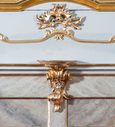 Zdjęcie nr 15: Nastawa ołtarzowa jednoosiowa, jednokondygnacyjna ze zwieńczeniem, na podwójnym cokole. Mensa drewniana, sarkofagowa. W polu antepedium stylizowane elementy rocaille’owe ujęte ornamentem roślinnym. Kondygnacja nastawy flankowana pilastrami oraz stojącą przed nimi parą kolumn o kapitelach kompozytowych. Cokoły kolumn profilowane, ustawione skośnie względem lica. Podpory dźwigają pełne belkowanie o wklęsłej linii, wyłamane na ich osiach, połączone nad polem środkowym gzymsem wygiętym w łuk oraz fragmenty przerwanego przyczółka z klęczącą parą adorujących aniołów. W polu środkowym obraz z przedstawieniem św. Michała Archanioła ujęty profilowaną ramą w formie stojącego prostokąta z dolną krawędzią wyniesioną w łuk i zamkniętego łukiem nadwieszonym z uskokiem. Na cokołach, obok kolumn, po lewej stronie wazon z kwiatami, po prawej święta niewiasta (św. Anna?). Kondygnacja ujęta ażurowymi uszami utworzonymi z rocaille’ów, kratki regencyjnej oraz rozwiniętych kwiatów. Zwieńczenie w formie zbliżonej do stojącego prostokąta o wklęsłych bokach zwężających się ku górze z uszakami, zamknięte falistym gzymsem. W polu obraz z przedstawieniem św. Hieronima w profilowanej ramie w formie stojącego prostokąta o wklęsłych bokach i dolnych narożach rozszerzającego się ku dołowi, zamkniętego łukiem nadwieszonym z uskokami. Cokoły nastawy dekorowane płycinami o fantazyjnym zarysie oraz w formie leżących prostokątów. Trzony pilastrów zdobione płycinami; wewnętrzna para wypełniona rocaille’em. Pole główne, zwieńczenie oraz uszaki dekorowane elementami rocaille’owymi. Zwieńczenie ujęte roślinnymi festonami. Struktura polichromowana na biało; cokoły, ołtarz i predella marmoryzowane w kolorze beżowym; kolumny, ornamentyka i profile złocone i srebrzone.