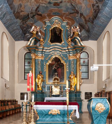 Zdjęcie nr 2: Nastawa ołtarzowa jednoosiowa, jednokondygnacyjna ze zwieńczeniem, na podwójnym cokole. Mensa drewniana, późniejsza, wklęsło-wypukła, dekorowana na krawędziach i ścianie frontowej motywami roślinnymi. Kondygnacja nastawy ujęta zwielokrotnionymi pilastrami o kapitelach kompozytowych ustawionymi skośnie oraz stojącą przed nimi parą kolumn o o takich samych kapitelach. Podpory dźwigają pełne belkowanie, o wklęsło-wypukłym zarysie, wyłamane na ich osi; nad polem środkowym przyjmujące formę łuku odcinkowego. Kolumny podtrzymują przerwany przyczółek, na którym klęczą figury aniołów. Podpory ustawione zostały na profilowanych cokołach. W polu środkowym obraz z przedstawieniem Nawiedzenia Najświętszej Marii Panny w profilowanej ramie w kształcie stojącego prostokąta zamkniętego łukiem nadwieszonym z uskokiem. Pole flankowane przez figury św. Anny z prawej strony i św. Joachima z lewej. Zwieńczenie w formie wydłużonego, stojącego prostokąta ujętego spływami wolutowymi, zamkniętego gzymsem w kształcie łuku nadwieszonego. W polu obraz z przedstawieniem św. Moniki w profilowanej ramie w kształcie stojącego prostokąta o wklęsłych bokach, zamkniętego łukiem nadwieszonym. Pod mensą rozeta z czterema palmetami. W partii cokołu płycina. Trzony pilastrów dekorowane płycinami z rocaille’m. Pole obrazowe flankuje rocaille, nad łukiem rozeta z liśćmi i rocaille. Kondygnacja ujęta uszami utworzonymi z ażurowego rocaille’a i kratką regencyjną. Na belkowaniu dwa rocaille’owe wazony. Woluty spływów zwieńczenia zdobione rocaille’m; ponad obrazem rocaille z kratką regencyjną. Struktura w całości marmoryzowana na niebiesko; kolumny, ornamentyka oraz profile złocone, skrzydła aniołów srebrzone.