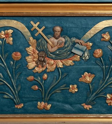 Zdjęcie nr 7: Nastawa ołtarzowa jednoosiowa, jednokondygnacyjna ze zwieńczeniem, na podwójnym cokole. Mensa drewniana, prostopadłościenna. Antepedium w formie leżącego prostokąta ujęte profilowaną ramą. W polu płaskorzeźbiona półpostać św. Hieronima, ujętego płatkami kwiatu na długiej, wygiętej łodydze, flankowana parą banderol. Prawą, ugiętą ręką podtrzymuje podwójny krzyż, w dłoni zaś kamień; lewą wyciągniętą w bok trzyma otwartą księgę. Święty ukazany został jako starzec. Twarz ma pociągłą, o wysokim czole, okoloną długą brodą; włosy po bokach głowy. Tors odsłonięty, postać przewiązana wokół gęsto drapowanym płaszczem. Przy prawym boku lew. Pole wypełnione płaskorzeźbionymi, wijącymi się ukwieconymi łodygami. Kondygnacja nastawy o wklęsłym licu, ujęta parą zwielokrotnionych pilastrów oraz stojącą przed nimi parą kolumn o kapitelach kompozytowych. Podpory dźwigają pełne belkowanie o silnie wysuniętym gzymsie, wyłamane na ich osi oraz przerwany przyczółek na linii kolumn na którym siedzi para puttów. Po zewnętrznej stronie kolumn figury króla Dawida po lewej i św. Floriana po prawej stronie. W polu środkowym nisza w formie stojącego prostokąta ujęta profilowaną ramą; wewnątrz mniejszy obraz z przedstawieniem św. Józefa w profilowanej ramie w kształcie stojącego prostokąta zwieńczonego łukiem wklęsło-wypukłym. Zwieńczenie w postaci stojącego prostokąta o wklęsłych bokach ujętego spływami wolutowymi i zakończone glorią promienistą z płaskorzeźbionym monogramem MARYA w otoczeniu obłoków. W polu obraz z przedstawieniem św. Grzegorza w profilowanej ramie w formie stojącego prostokąta o wklęsłych bokach i narożach, zamkniętej łukiem nadwieszonym. Kondygnacja ujęta ażurowymi uszami utworzonymi z motywów roślinnych i karbowanej wstęgi. W partii belkowania nad polem środkowym rocaille’owy kartusz. Nad obrazem, w zwieńczeniu, muszla i kampanule; woluty dekorowane festonami. Struktura polichromowana na kolor jasnoniebieski; trzony kolumn, antepedium i profile na niebiesko; ornamentyka i profile złocone i srebrzone.