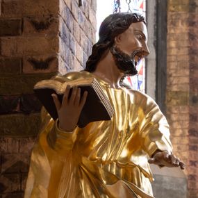 Zdjęcie nr 1: Rzeźba drążona na cokole z przedstawieniem św. Łukasza w całej postaci. Figura w kontrapoście, w skręcie w prawo, z głową zwróconą w lewo; w prawej wyciągniętej w bok ręce trzyma księgę, lewą unosi równolegle. Głowę ma lekko pochyloną; twarz szczupłą z wysokim czołem, o szeroko otwartych, ciemnych oczach, wąskim nosie i rozchylonych ustach. Twarz jest okolona krótkim kręconym zarostem oraz włosami układającymi się w spływające na kark fale. Święty jest ubrany w długą, przylegającą do ciała tunikę oraz płaszcz przewiązany diagonalnie z prawego ramienia przez plecy i wokół lewego biodra, złapany z przodu. Polichromia naturalistyczna w odsłoniętych partiach ciała, szaty złocone, księga brązowo-złota. Z uwagi na swoje aktualne ustawienie na ołtarzu głównym wydrążenie zostało zasłonięte zamalowanym na złoto materiałem.