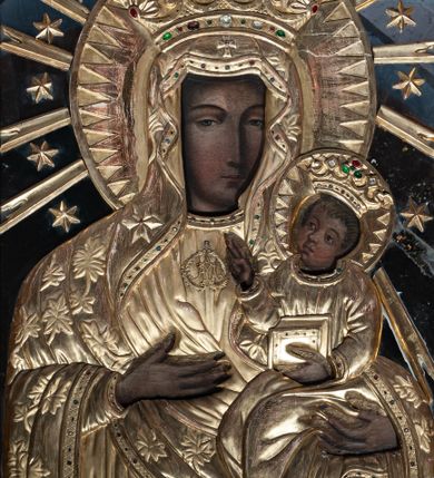 Zdjęcie nr 1: Obraz w kształcie stojącego prostokąta w prostej, profilowanej ramie. Madonna w typie Hodegetrii, przedstawiona frontalnie, w półpostaci. Głowa zwrócona lekko w lewo, twarz pociągła, o wyrazistych rysach, ciemnej karnacji, długim nosie, zwężonych oczach i drobnych ustach. Prawą ręką wskazuje na trzymane na lewej ręce, siedzące Dzieciątko Jezus zwrócone w trzech czwartych w prawo, z głową przechyloną na lewe ramię. Twarz ma owalną, o ciemnej karnacji i wyrazistych rysach. Włosy brązowe, kręcone, zaczesane na twarz. Lewą rączką podtrzymuje księgę, prawą ma uniesioną w geście błogosławieństwa. Ubrania postaci przykrywają drewniane, rzeźbione i złocone sukienki. Maria jest ubrana w jednolitą suknię z monogramem pod szyją i maforion dekorowany liśćmi. Na prawym ramieniu ma pięcioramienną gwiazdę. Dzieciątko ma na sobie gładką sukienkę. Wokół głów postaci promieniste nimby, od nimbu Marii odchodzą promienie umieszczone naprzemiennie z gwiazdkami; na głowach otwarte korony dekorowane kameryzacją. Tło tworzą lustra.