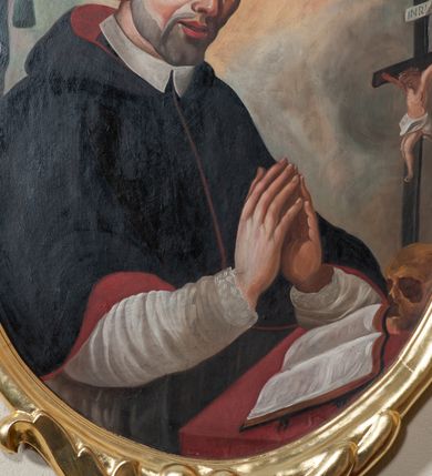 Zdjęcie nr 3: Obraz w kształcie stojącego owalu z wizerunkiem św. Stanisława Kazimierczyka. Bliżej lewej krawędzi płótna została ukazana do pasa postać Stanisława, który ma ręce złożone do modlitwy, a wzrok kieruje ku górze. Ma trójkątną twarz o dużych, głęboko osadzonych oczach, wąskim nosie i szerokich, lekko rozchylonych ustach. Po policzkach spływają mu łzy. Krótkie włosy ma zaczesane na boki, a na głowie wyciętą tonsurę. Jest ubrany w biały habit i podbitą czerwienią czarną pelerynkę z kapturem. Przed nim, na pokrytym czerwoną tkaniną blacie leży otwarta księga, ludzka czaszka i krucyfiks. Za świętym widoczny fragment granatowej kotary ze zwisającym chwostem. Tło obrazu  niejednolite – za głową Stanisława i na linii jego wzroku jasnożółte, w pozostałych miejscach niebieskoszare. Obraz oprawiono w profilowaną, złoconą ramę dekorowaną od góry ornamentem rocaille’owym, a od dołu zwiniętymi od wewnątrz w woluty liśćmi. 