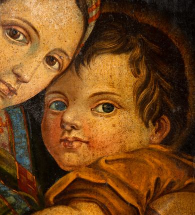 Zdjęcie nr 7: Obraz w kształcie stojącego owalu w drewnianej, profilowanej ramie. W centrum kompozycji siedzi Madonna trzymając obiema rękami na kolanach Jezusa, który jakby chowa się za nią, patrząc jenocześnie na widza. Maria została ukazana jako młoda kobieta o owalnej twarzy osadzonej na szerokiej szyi. Ma duże, ciemne oczy, wąski nos i niewielkie usta. Jest ubrana w czerwoną suknię, na ramiona ma zarzuconą ciemnozieloną chustę dekorowaną jaśniejszymi pasami z czerwonym ornamentem, przechodzącą w szeroki, złoty pas na plecach; jej nogi okrywa granatowy płaszcz. Dzieciątko kładzie łokieć na ręce Marii, nogi ma zwrócone w stronę widza. Jest ubrane w żółtą sukienkę. Za nimi, z prawej strony stoi młody św. Jan Chrzciciel. Ręce składa do modlitwy, jest ubrany w płaszcz ze skóry, lewą ręką przytrzymuje niewielki krzyżyk. Obaj chłopcy mają pełne twarze, duże, szeroko otwarte oczy i zaróżowione policzki; krótkie ciemnobrązowe włosy mają zaczesane na boki. Tło obrazu jednolite, ciemne.  