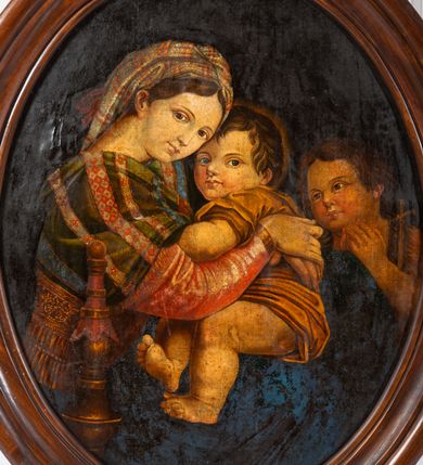 Zdjęcie nr 6: Obraz w kształcie stojącego owalu w drewnianej, profilowanej ramie. W centrum kompozycji siedzi Madonna trzymając obiema rękami na kolanach Jezusa, który jakby chowa się za nią, patrząc jenocześnie na widza. Maria została ukazana jako młoda kobieta o owalnej twarzy osadzonej na szerokiej szyi. Ma duże, ciemne oczy, wąski nos i niewielkie usta. Jest ubrana w czerwoną suknię, na ramiona ma zarzuconą ciemnozieloną chustę dekorowaną jaśniejszymi pasami z czerwonym ornamentem, przechodzącą w szeroki, złoty pas na plecach; jej nogi okrywa granatowy płaszcz. Dzieciątko kładzie łokieć na ręce Marii, nogi ma zwrócone w stronę widza. Jest ubrane w żółtą sukienkę. Za nimi, z prawej strony stoi młody św. Jan Chrzciciel. Ręce składa do modlitwy, jest ubrany w płaszcz ze skóry, lewą ręką przytrzymuje niewielki krzyżyk. Obaj chłopcy mają pełne twarze, duże, szeroko otwarte oczy i zaróżowione policzki; krótkie ciemnobrązowe włosy mają zaczesane na boki. Tło obrazu jednolite, ciemne.  