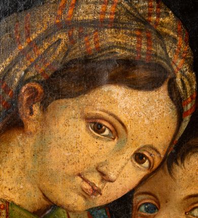 Zdjęcie nr 2: Obraz w kształcie stojącego owalu w drewnianej, profilowanej ramie. W centrum kompozycji siedzi Madonna trzymając obiema rękami na kolanach Jezusa, który jakby chowa się za nią, patrząc jenocześnie na widza. Maria została ukazana jako młoda kobieta o owalnej twarzy osadzonej na szerokiej szyi. Ma duże, ciemne oczy, wąski nos i niewielkie usta. Jest ubrana w czerwoną suknię, na ramiona ma zarzuconą ciemnozieloną chustę dekorowaną jaśniejszymi pasami z czerwonym ornamentem, przechodzącą w szeroki, złoty pas na plecach; jej nogi okrywa granatowy płaszcz. Dzieciątko kładzie łokieć na ręce Marii, nogi ma zwrócone w stronę widza. Jest ubrane w żółtą sukienkę. Za nimi, z prawej strony stoi młody św. Jan Chrzciciel. Ręce składa do modlitwy, jest ubrany w płaszcz ze skóry, lewą ręką przytrzymuje niewielki krzyżyk. Obaj chłopcy mają pełne twarze, duże, szeroko otwarte oczy i zaróżowione policzki; krótkie ciemnobrązowe włosy mają zaczesane na boki. Tło obrazu jednolite, ciemne.  