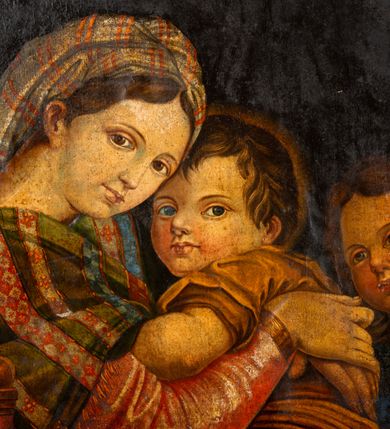 Zdjęcie nr 5: Obraz w kształcie stojącego owalu w drewnianej, profilowanej ramie. W centrum kompozycji siedzi Madonna trzymając obiema rękami na kolanach Jezusa, który jakby chowa się za nią, patrząc jenocześnie na widza. Maria została ukazana jako młoda kobieta o owalnej twarzy osadzonej na szerokiej szyi. Ma duże, ciemne oczy, wąski nos i niewielkie usta. Jest ubrana w czerwoną suknię, na ramiona ma zarzuconą ciemnozieloną chustę dekorowaną jaśniejszymi pasami z czerwonym ornamentem, przechodzącą w szeroki, złoty pas na plecach; jej nogi okrywa granatowy płaszcz. Dzieciątko kładzie łokieć na ręce Marii, nogi ma zwrócone w stronę widza. Jest ubrane w żółtą sukienkę. Za nimi, z prawej strony stoi młody św. Jan Chrzciciel. Ręce składa do modlitwy, jest ubrany w płaszcz ze skóry, lewą ręką przytrzymuje niewielki krzyżyk. Obaj chłopcy mają pełne twarze, duże, szeroko otwarte oczy i zaróżowione policzki; krótkie ciemnobrązowe włosy mają zaczesane na boki. Tło obrazu jednolite, ciemne.  
