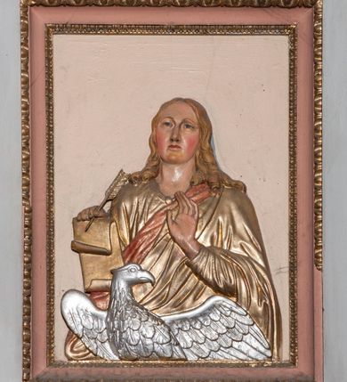 Zdjęcie nr 3: Ambona przyścienna składająca się z kosza, zaplecka, baldachimu i schodów z balustradą, zawieszona przy wschodnim filarze nawy. Kosz na planie sześcioboku, w narożach  ustawiono pilastry wsparte na cokołach, pomiędzy którymi prostokątne pola. Wszystkie płaszczyzny zdobione prostokątnymi płycinami dekorowanymi płaskorzeźbionymi postaciami ewangelistów oraz Chrystusa ukazanymi w półpostaci. Każdy z ewangelistów jest ubrany w długą złotą suknię i złoty płaszcz, trzyma w rękach otwartą księgę (św. Jan zwój), towarzyszy mu atrybut umożliwiający identyfikację. Chrystus jest ustawiony frontalnie, prawą ręką błogosławi, w lewej trzyma jabłko królewskie. Ma opadające na ramiona, zwinięte w pukle włosy oraz brodę. Podstawa kosza stożkowata, ujęta w narożach listwami, z pozłacaną szyszką od dołu. Zaplecek w kształcie prostokąta z płyciną ujętą pilastrami, wewnątrz której aplikowany stylizowany ornament roślinny. Baldachim powtarzający plan kosza, ujęty profilowanym gzymsem, wyłamanym w narożach, zwieńczony pełnoplastyczną figurą Chrystusa Zmartwychwstałego trzymającego krzyż, ustawioną na wielobocznej podstawie wspartej na sześciu wolutach. Chrystus został ukazany w całej postaci, z prawą ręką uniesioną w geście błogosławieństwa, lewą przytrzymującą krzyż. Ma owalną twarz okoloną długimi włosami, które spływają mu na ramiona i plecy; nad głową okrągły nimb. Jest ubrany w długą suknię, na którą ma zarzucony płaszcz spięty na ramionach. Obie szaty łamią się ostrymi fałdami. W podniebiu baldachimu znajduje się podwójna, ośmioramienna gwiazda wydzielona pozłacanymi listwami, z lampą na środku. Balustrada z profilowaną poręczą, artykułowana romboidalnymi płycinami i pilastrami. Kolorystyka pastelowa, jasna. Struktura w kolorze jasnoszarym, płyciny jasnobeżowe, detal architektoniczny, ornamenty oraz szaty pozłacane, atrybuty ewangelistów posrebrzane.