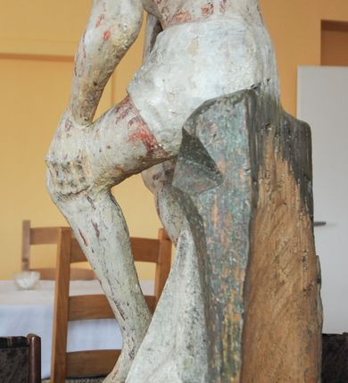 Zdjęcie nr 4: Rzeźba pełna, całopostaciowa, ustawiona na niewysokim cokole. Chrystus ukazany w pozycji siedzącej, na podstawie imitującej blok skalny. Prawą ręką, opartą na udzie  podtrzymuje głowę, lewą dłoń opiera na lewej nodze; kolana ma rozchylone, lewą stopę ustawioną przed prawą. Chrystus ma pociągłą twarz o wydatnych kościach policzkowych, wąskie brwi opadające prostą linią w dół, długi nos, zagłębione oczy i wyraźnie zaznaczone usta. Długie włosy opadają mu na ramiona i plecy, broda dzieli się w dwa pukle; na głowie grube zwoje korony cierniowej.  Biodra ma przepasane białym perizonium, którego długi, wolny koniec opada między udami i za lewą nogą aż na podłoże. Na całym ciele zaznaczono ślady męki – równomiernie rozmieszczone krople spływającej krwi. W partiach ciała polichromia naturalistyczna.