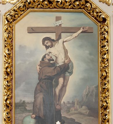 Zdjęcie nr 6: Ołtarz architektoniczny, przyścienny, jednokondygnacyjny, jednoosiowy ze zwieńczeniem. Mensa w typie sarkofagowym, na wysokim cokole, gładka, górna partia cokołu oddzielona profilowanymi listwami. Na mensie ustawiono tabernakulum w formie prostopadłościennej szafki, ze ścianką frontową ujętą kanelowanymi pilastrami jońskimi wspierającymi gzyms, pośrodku przyczółek utworzony z dwóch stykających się wolut, wypełniony muszlą. Drzwiczki w kształcie stojącego prostokąta zamknięte łukiem półkolistym nadwieszonym z przedstawieniem kielicha z hostią. 
Nastawa ustawiona na wysokim cokole ujęta parami pilastrów, z których wewnętrzne ustawione ukośnie oraz stojącymi na ich tle kolumnami, podtrzymującymi odcinki belkowania oraz fragmenty naczółków. Pole środkowe z wnęką w kształcie stojącego prostokąta o ściętych górnych narożach, ujęte ozdobną ramą wypełnioną ażurowym ornamentem akantowym. W niej obraz z przedstawienie św. Franciszka obejmującego ukrzyżowanego Chrystusa. Pola cokołów i pilastrów są wypełnione stylizowaną wicią akantu, boki ołtarza flankowane ażurową wicią akantową z rozetą. Zwieńczenie ujęte spływami wolutowymi, zakończone gzymsem w kształcie łuku półkolistego nadwieszonego. W zwieńczeniu płaskorzeźbione przedstawienie św. Antoniego Padewskiego w prostokątnej ramie o ściętych ćwierćkoliście dolnych narożach i zakończonej łukiem nadwieszonym z uskokiem. Całość struktury ołtarza polichromowana w kremowym odcieniu, wnętrza płycin szare, detal architektoniczny i ornamenty pozłacane.