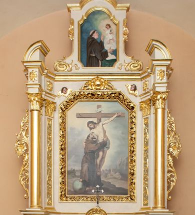 Zdjęcie nr 1: Ołtarz architektoniczny, przyścienny, jednokondygnacyjny, jednoosiowy ze zwieńczeniem. Mensa w typie sarkofagowym, na wysokim cokole, gładka, górna partia cokołu oddzielona profilowanymi listwami. Na mensie ustawiono tabernakulum w formie prostopadłościennej szafki, ze ścianką frontową ujętą kanelowanymi pilastrami jońskimi wspierającymi gzyms, pośrodku przyczółek utworzony z dwóch stykających się wolut, wypełniony muszlą. Drzwiczki w kształcie stojącego prostokąta zamknięte łukiem półkolistym nadwieszonym z przedstawieniem kielicha z hostią. 
Nastawa ustawiona na wysokim cokole ujęta parami pilastrów, z których wewnętrzne ustawione ukośnie oraz stojącymi na ich tle kolumnami, podtrzymującymi odcinki belkowania oraz fragmenty naczółków. Pole środkowe z wnęką w kształcie stojącego prostokąta o ściętych górnych narożach, ujęte ozdobną ramą wypełnioną ażurowym ornamentem akantowym. W niej obraz z przedstawienie św. Franciszka obejmującego ukrzyżowanego Chrystusa. Pola cokołów i pilastrów są wypełnione stylizowaną wicią akantu, boki ołtarza flankowane ażurową wicią akantową z rozetą. Zwieńczenie ujęte spływami wolutowymi, zakończone gzymsem w kształcie łuku półkolistego nadwieszonego. W zwieńczeniu płaskorzeźbione przedstawienie św. Antoniego Padewskiego w prostokątnej ramie o ściętych ćwierćkoliście dolnych narożach i zakończonej łukiem nadwieszonym z uskokiem. Całość struktury ołtarza polichromowana w kremowym odcieniu, wnętrza płycin szare, detal architektoniczny i ornamenty pozłacane.
