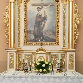 Zdjęcie nr 1: Ołtarz architektoniczny, przyścienny, jednokondygnacyjny, jednoosiowy ze zwieńczeniem. Mensa w typie sarkofagowym, na wysokim cokole, gładka, górna partia cokołu oddzielona profilowanymi listwami. Na mensie ustawiono tabernakulum w formie prostopadłościennej szafki, ze ścianką frontową ujętą kanelowanymi pilastrami jońskimi wspierającymi gzyms, pośrodku przyczółek utworzony z dwóch stykających się wolut, wypełniony muszlą. Drzwiczki w kształcie stojącego prostokąta zamknięte łukiem półkolistym nadwieszonym z przedstawieniem kielicha z hostią. 
Nastawa ustawiona na wysokim cokole ujęta parami pilastrów, z których wewnętrzne ustawione ukośnie oraz stojącymi na ich tle kolumnami, podtrzymującymi odcinki belkowania oraz fragmenty naczółków. Pole środkowe z wnęką w kształcie stojącego prostokąta o ściętych górnych narożach, ujęte ozdobną ramą wypełnioną ażurowym ornamentem akantowym. W niej obraz z przedstawienie św. Franciszka obejmującego ukrzyżowanego Chrystusa. Pola cokołów i pilastrów są wypełnione stylizowaną wicią akantu, boki ołtarza flankowane ażurową wicią akantową z rozetą. Zwieńczenie ujęte spływami wolutowymi, zakończone gzymsem w kształcie łuku półkolistego nadwieszonego. W zwieńczeniu płaskorzeźbione przedstawienie św. Antoniego Padewskiego w prostokątnej ramie o ściętych ćwierćkoliście dolnych narożach i zakończonej łukiem nadwieszonym z uskokiem. Całość struktury ołtarza polichromowana w kremowym odcieniu, wnętrza płycin szare, detal architektoniczny i ornamenty pozłacane.