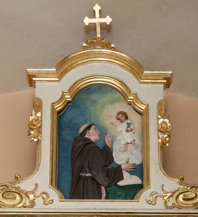 Zdjęcie nr 3: Ołtarz architektoniczny, przyścienny, jednokondygnacyjny, jednoosiowy ze zwieńczeniem. Mensa w typie sarkofagowym, na wysokim cokole, gładka, górna partia cokołu oddzielona profilowanymi listwami. Na mensie ustawiono tabernakulum w formie prostopadłościennej szafki, ze ścianką frontową ujętą kanelowanymi pilastrami jońskimi wspierającymi gzyms, pośrodku przyczółek utworzony z dwóch stykających się wolut, wypełniony muszlą. Drzwiczki w kształcie stojącego prostokąta zamknięte łukiem półkolistym nadwieszonym z przedstawieniem kielicha z hostią. 
Nastawa ustawiona na wysokim cokole ujęta parami pilastrów, z których wewnętrzne ustawione ukośnie oraz stojącymi na ich tle kolumnami, podtrzymującymi odcinki belkowania oraz fragmenty naczółków. Pole środkowe z wnęką w kształcie stojącego prostokąta o ściętych górnych narożach, ujęte ozdobną ramą wypełnioną ażurowym ornamentem akantowym. W niej obraz z przedstawienie św. Franciszka obejmującego ukrzyżowanego Chrystusa. Pola cokołów i pilastrów są wypełnione stylizowaną wicią akantu, boki ołtarza flankowane ażurową wicią akantową z rozetą. Zwieńczenie ujęte spływami wolutowymi, zakończone gzymsem w kształcie łuku półkolistego nadwieszonego. W zwieńczeniu płaskorzeźbione przedstawienie św. Antoniego Padewskiego w prostokątnej ramie o ściętych ćwierćkoliście dolnych narożach i zakończonej łukiem nadwieszonym z uskokiem. Całość struktury ołtarza polichromowana w kremowym odcieniu, wnętrza płycin szare, detal architektoniczny i ornamenty pozłacane.
