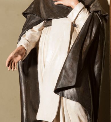 Zdjęcie nr 2: Rzeźba pełnoplastyczna, całopostaciowa, wydrążona od tyłu, na cokole.  Święty Dominik został ukazany frontalnie, w kontrapoście, z ciężarem na prawej nodze i sylwetką odchyloną do tyłu. Prawą rękę ma wysuniętą przed siebie, lewą składa na piersi. Głowę ma nieznacznie uniesioną, twarz pociągłą, okoloną krótką, brązową brodą i krótkimi, kręconymi włosami, czoło wysokie, wzrok skierowany ku górze. Święty jest ubrany w habit dominikański: białą tunikę przewiązaną czarnym pasem, biały szkaplerz oraz długą czarną kapę i krótką pelerynkę. Przy lewej nodze świętego siedzi mały, brązowy pies. 
Polichromia w partiach ciała naturalistyczna. 
